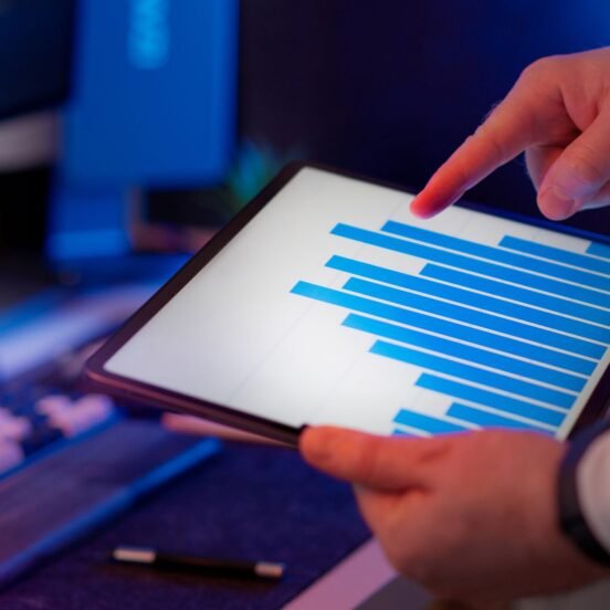 Business professional analyzing bar chart data on a tablet, representing pharma brand manager reviewing digital marketing analytics