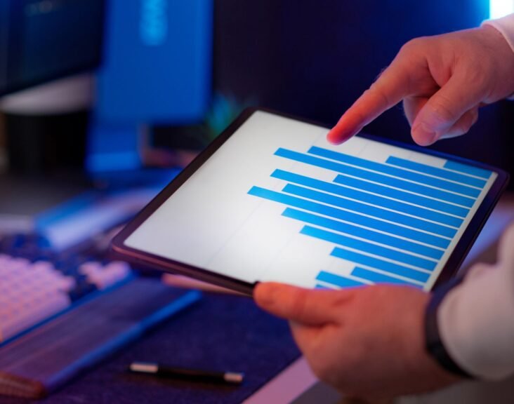 Business professional analyzing bar chart data on a tablet, representing pharma brand manager reviewing digital marketing analytics