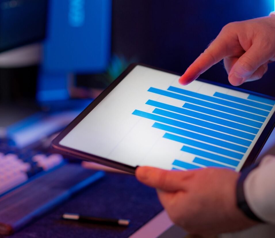 Business professional analyzing bar chart data on a tablet, representing pharma brand manager reviewing digital marketing analytics