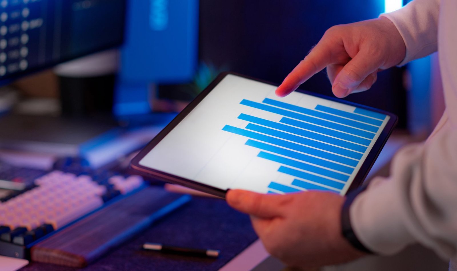 Business professional analyzing bar chart data on a tablet, representing pharma brand manager reviewing digital marketing analytics