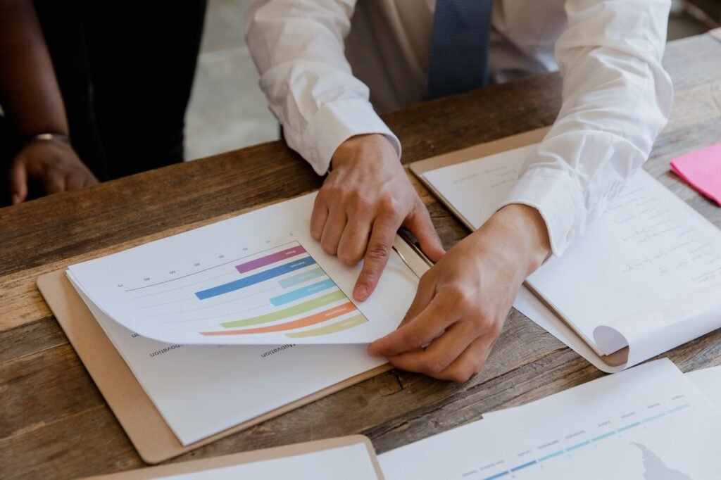 How to Evaluate a Pharmaceutical Digital Marketing Agency 5 Business professionals reviewing a colorful bar chart on paper during an agency evaluation meeting