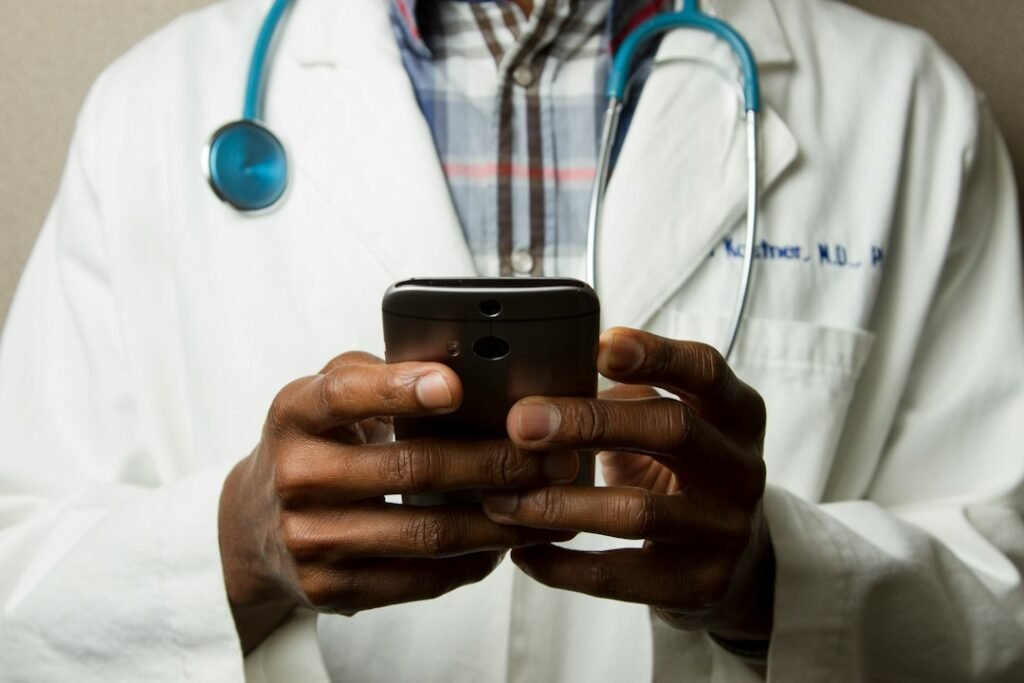 Omnichannel HCP Engagement Framework: 5 Layers, 90 Days 3 Doctor with stethoscope holding a smartphone, illustrating WhatsApp-based HCP engagement in India pharma marketing