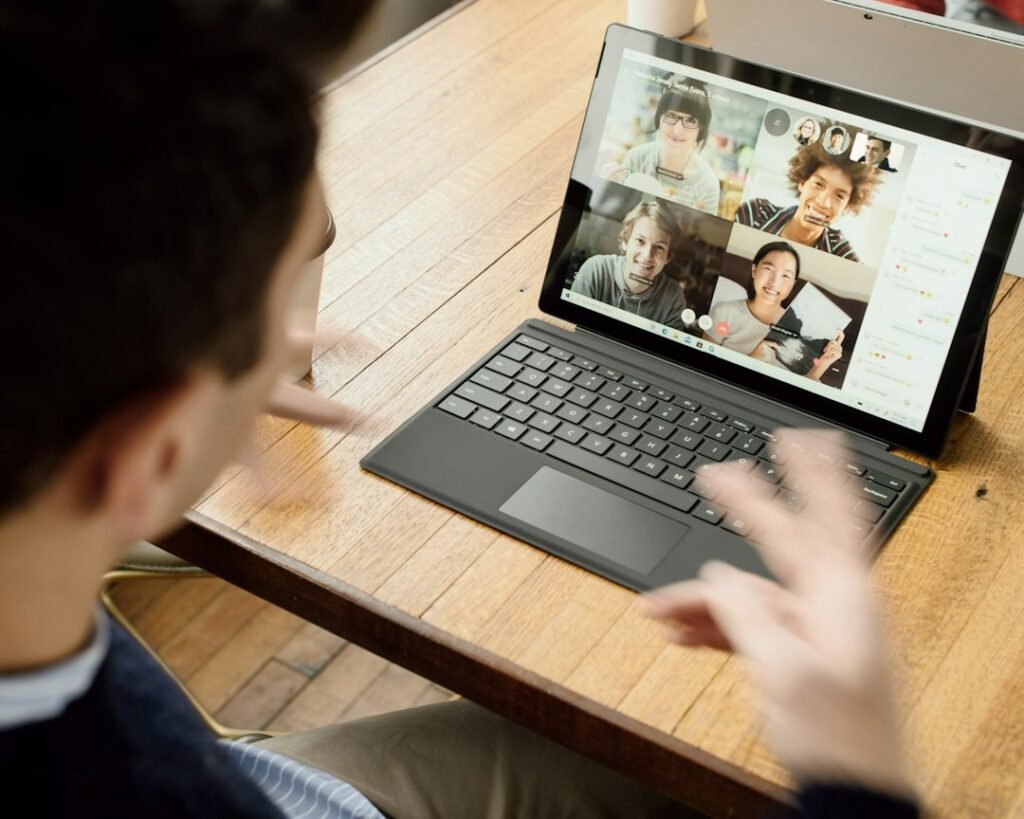 Professional using a tablet device for a multi-participant video call — representing digital channel tracking and omnichannel engagement measurement in pharma field force management