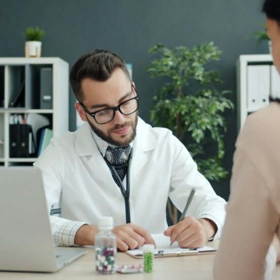 Doctor consulting at clinic desk with medication — representing the MR-HCP interaction at the heart of medical representative training