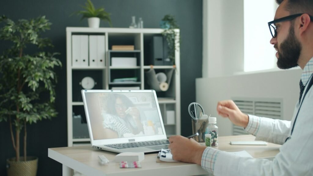 Doctor conducting a remote video consultation on a laptop with medication on the desk — illustrating remote e-detailing and digital HCP engagement for pharma MRs